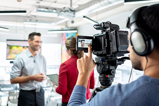 Media interview being recorded by a videographer.